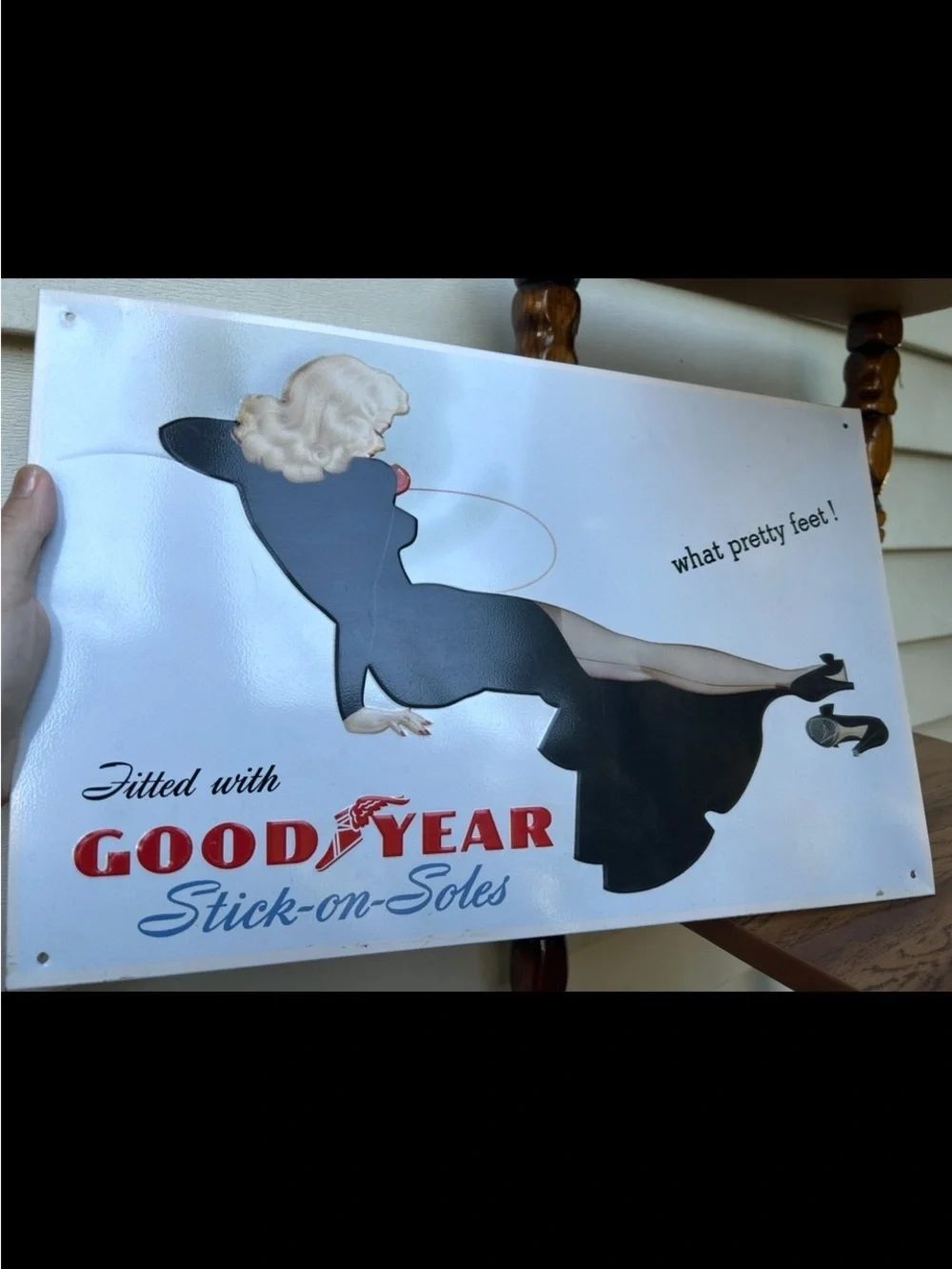 Vintage-style metal sign features a retro advertisement for Goodyear